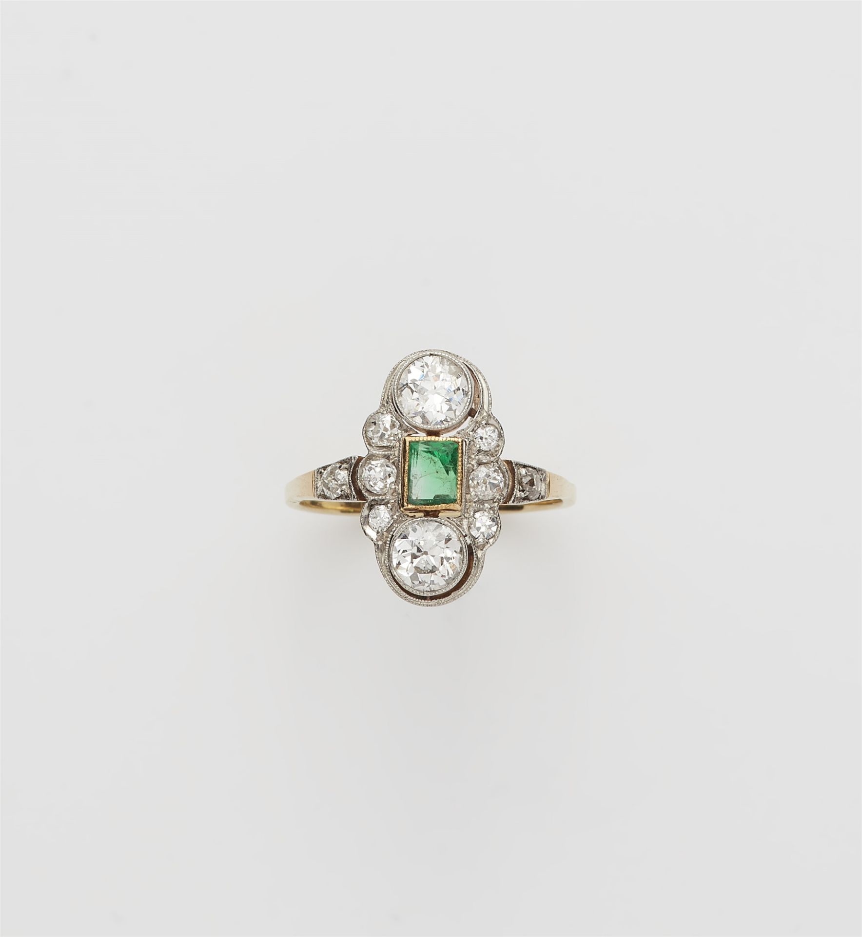 An Art Déco 14 kt gold platinum diamond and emerald ring.