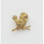 An 18k gold and ruby sparrow pin.