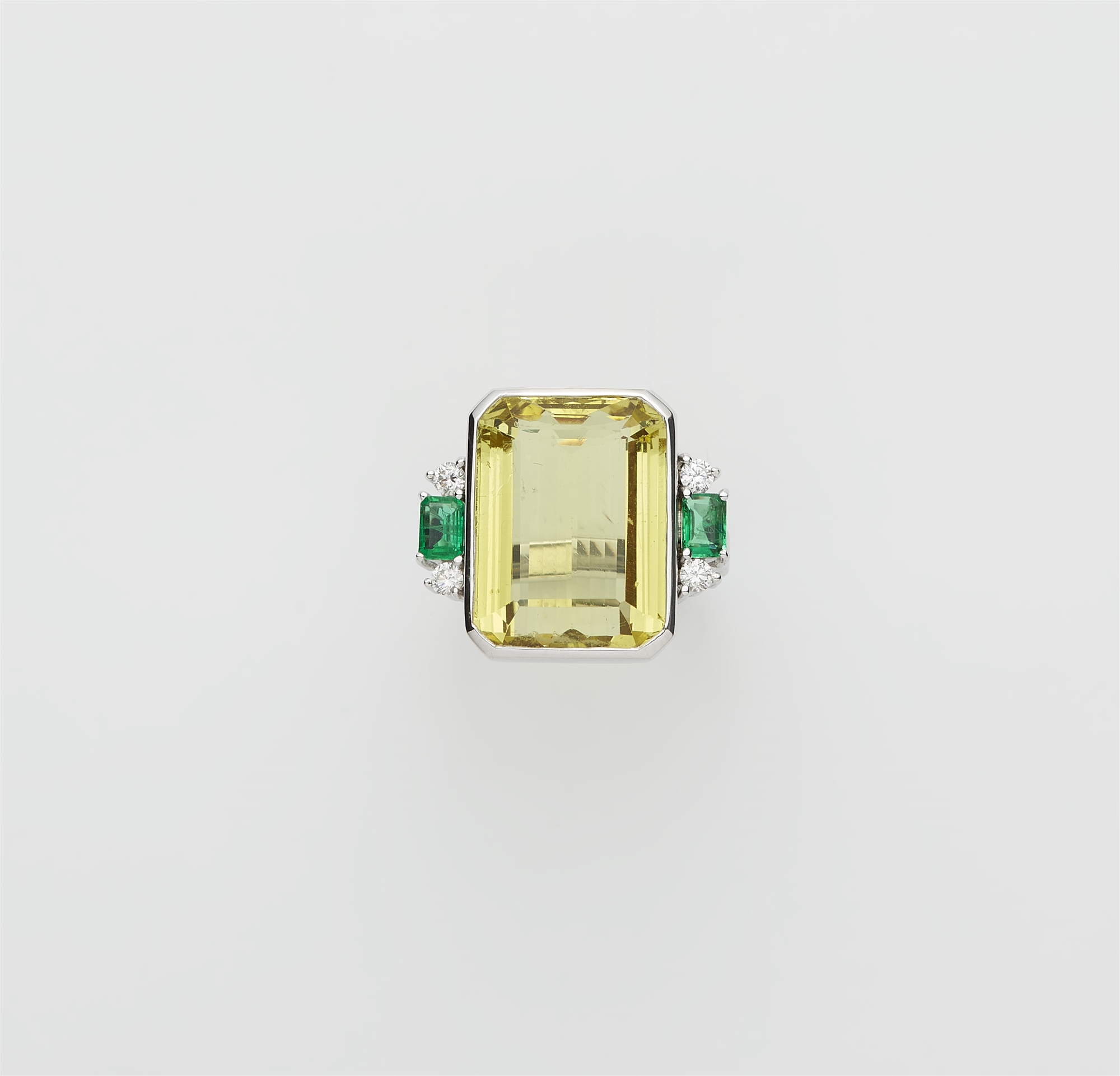 An 18k white gold diamond emerald and natural heliodor (lemon green beryl) ring.