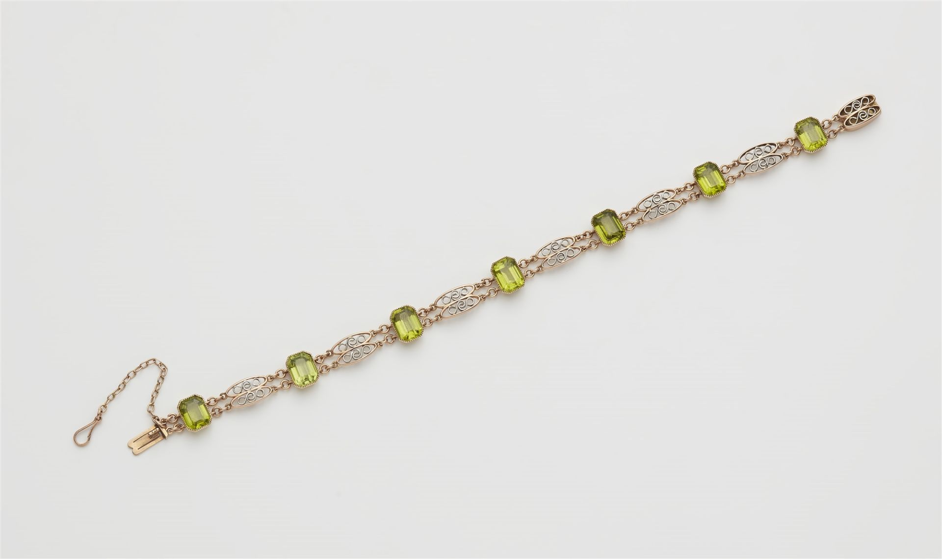 A 14k red gold platinum and peridot bracelet.