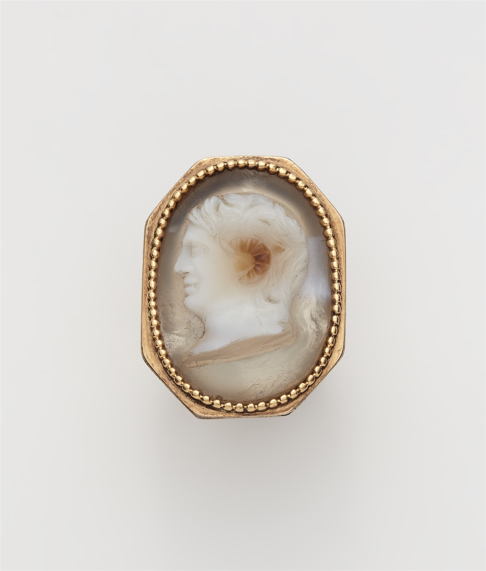 A possibly English Neoclassical 18k gold and layered chalcedony cameo ring with depiction of the hea