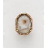 A possibly English Neoclassical 18k gold and layered chalcedony cameo ring with depiction of the hea