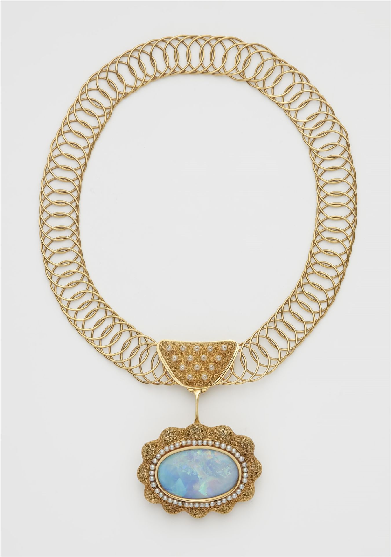 A German hand-forged 18k gold wire necklace with a large granulation and black opal pendant brooch.