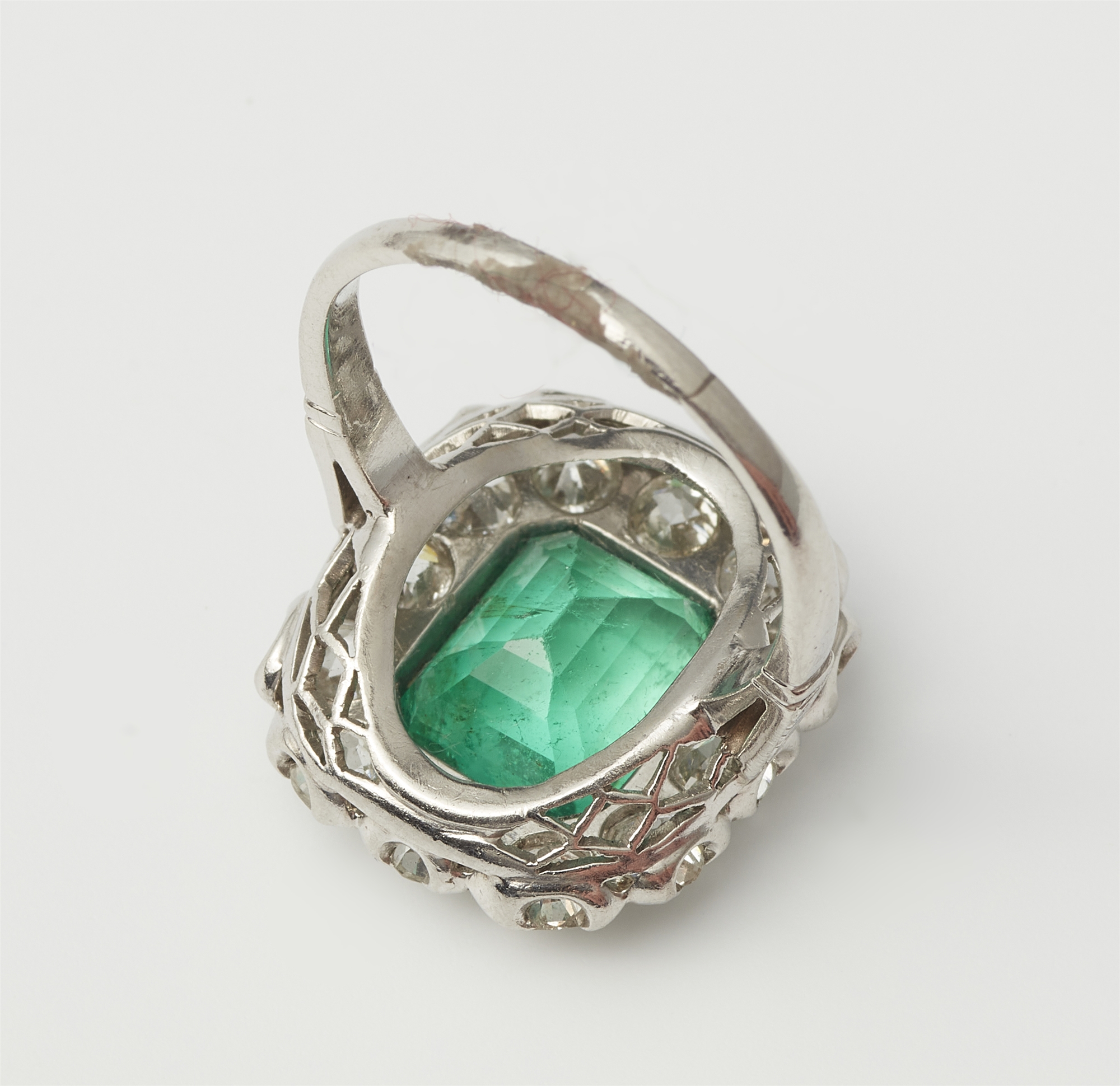 An Art Déco platinum iridium diamond and emerald cluster ring. - Image 2 of 2