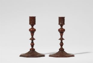 A museum quality pair of carved wood candlesticks