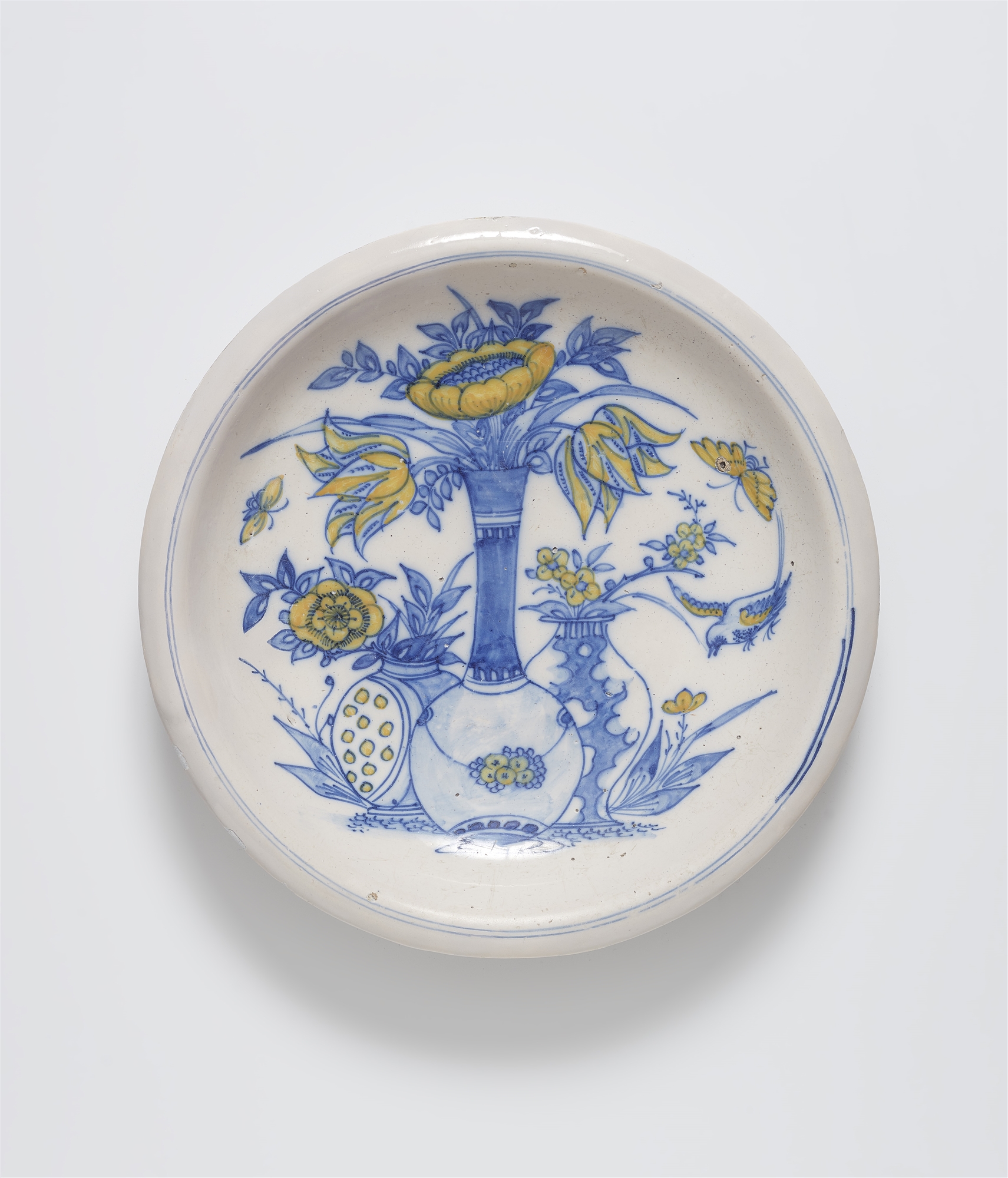 A faience dish painted in blue and yellow
