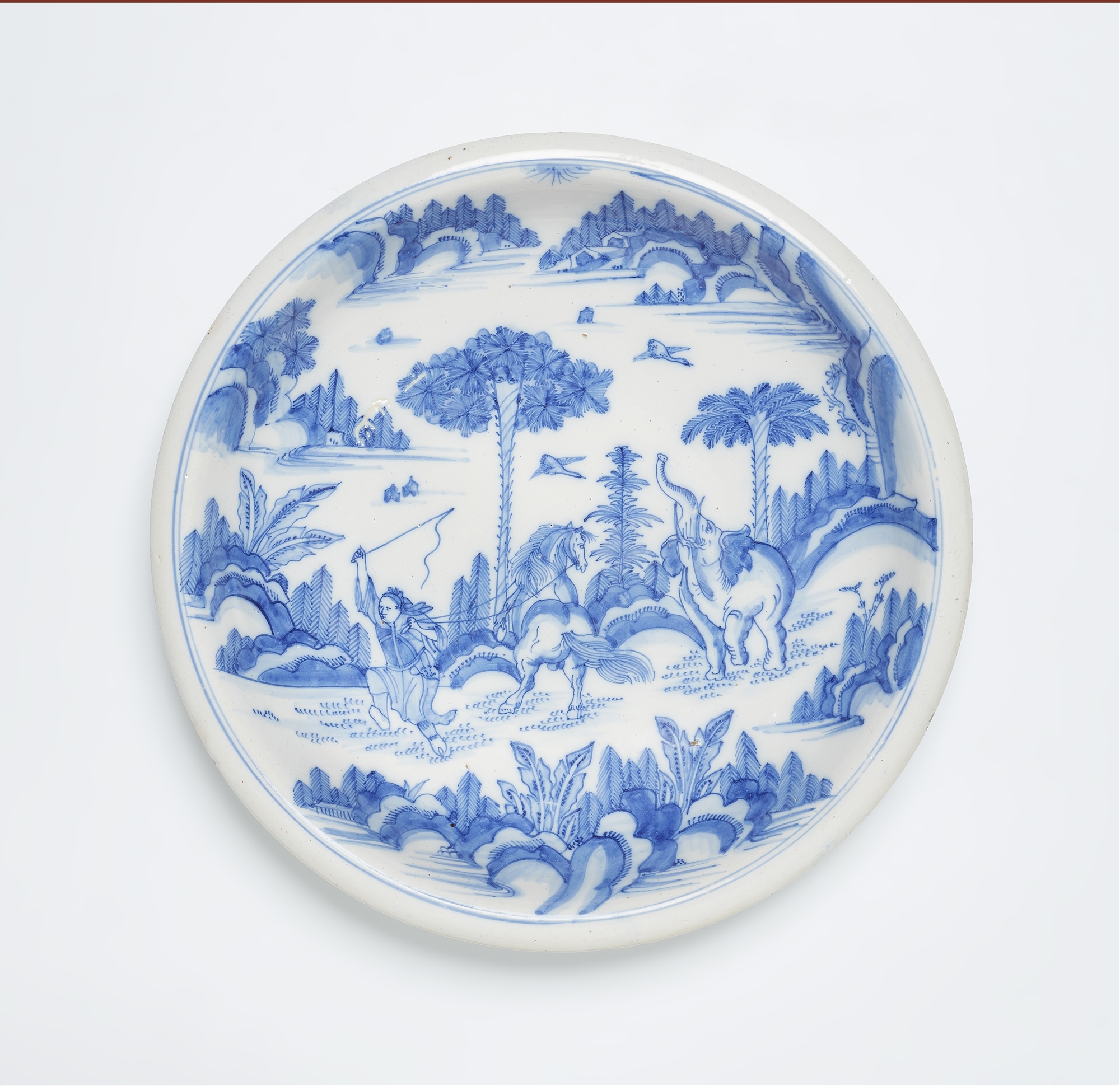 A faience dish with Chinoiserie motifs and an elephant