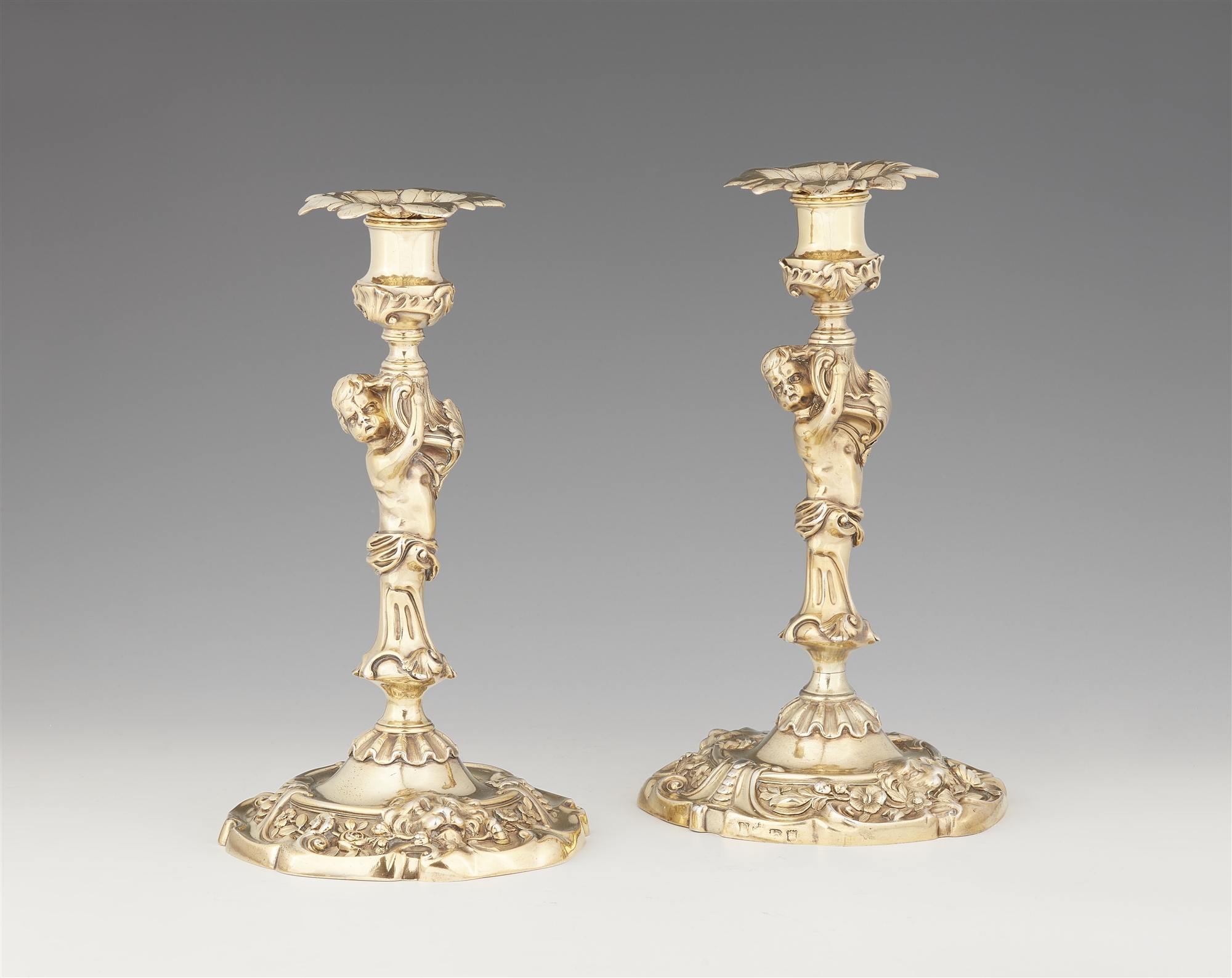 A pair of George II silver gilt candlesticks