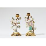 A pair of ormolu candlesticks mounted with Meissen porcelain figures of children in costumes