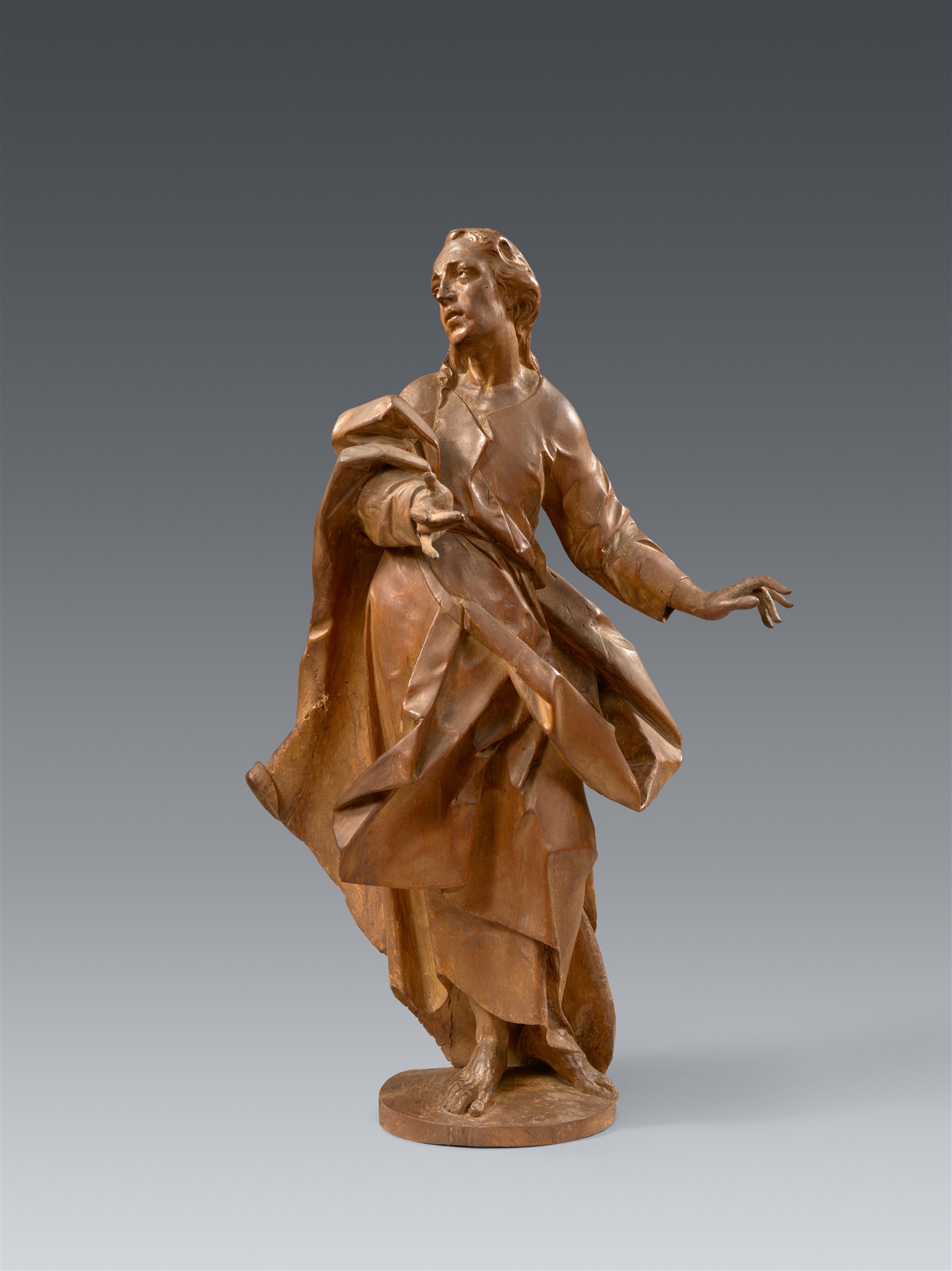 A carved limewood figure of St John from a Crucifixion by Johann Michael Fischer