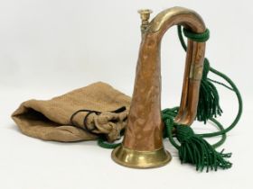 An early 20th century copper and brass bugle with bag.