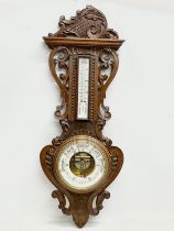 A large Victorian carved oak barometer. 36x98cm