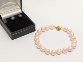 A pair of pearl earrings with a pearl bracelet. Measurements for bracelet open 21.5cmn