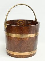 An early 20th century oak brass bound coal bucket by R.A. Lister & Co LTD. Dursley, England. Circa