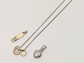 A silver necklace with 2 other silver pendants