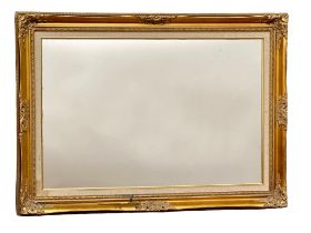 An ornate gilt framed mirror. 92x67cm