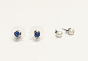 A pair of silver earrings with a pair of silver and pearl earrings.