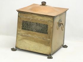 An Edwardian brass coal bin on lion paw feet. 37x33x43cm