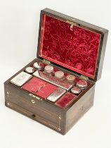 A Victorian rosewood vanity box with Mother of Pearl inlay and cut glass bottles with silver