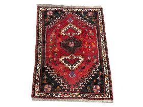 A vintage Iranian hand knotted rug. The Persian Rug Company. 83x121cm