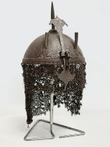 An old reproduction Indo-Persian steel battle helmet on stand.