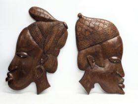 A pair of large carved African plaques. 41x76cm