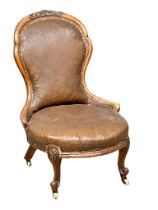 A Victorian walnut and leather balloon back nursing chair on cabriole legs.