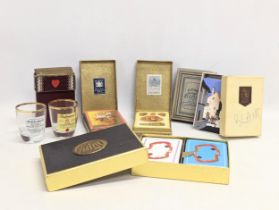 A collection of vintage playing cards with 2 whisky shot glasses.