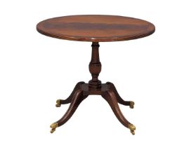 A Regency style mahogany inlaid pedestal lamp table on brass paw casters. 65x54.5cm