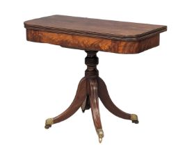 A late George III mahogany games table, with reeded column pedestal and brass feet with acranthus