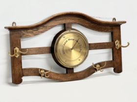 An early 20th century oak wall hanging barometer/hat and coat rack. 78x43cm
