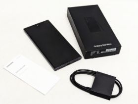 A Samsung Galaxy S23 Ultra phone with box and cable. In black.