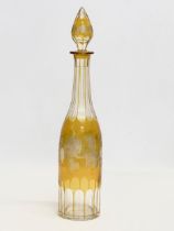 A tall early 20th century Bohemian amber stained and cut glass decanter with engraved flower and