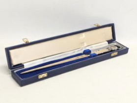 An ornate silver letter opener in case. Measures 29cm