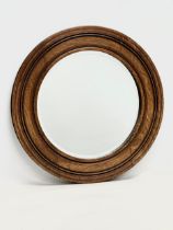 An Edwardian oak spinning wheel bevelled mirror. 50.5cm