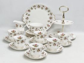 A 22 piece Royal Albert ‘Winsome’ tea service. 2 tier cake stand. Cake plate. 6 cups and 6