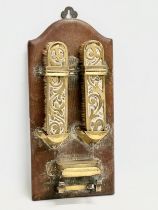 An Art Nouveau brass wall hanging clothes brush set on leather bound panel. Circa 1900. 17x35cm