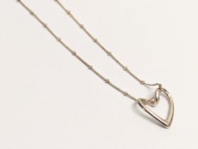 A silver pendant and necklace. 4.47g