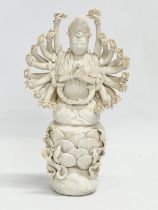 A 20th century Chinese praying Guanyin figure with multiple arms on lotus leaves. 25cm