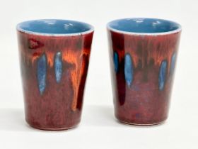 A pair of Poole Pottery mugs. 9.5cm