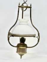 An early 20th century hanging brass oil lamp with glass shade. 37x75cm