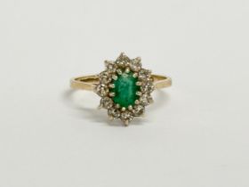 A 9ct gold emerald cluster ring. Size N.