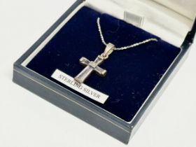 A silver cross necklace with box.