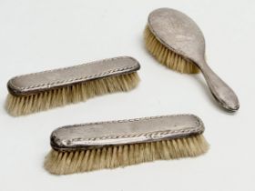 3 silver vanity brushes. A pair of early 20th century Boots Pure Drug Company silver vanity brushes,