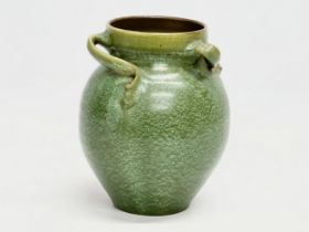 A C.H. Brannam Barnstable green sgraffito glazed vase with sweeping twist handles. 13x17cm