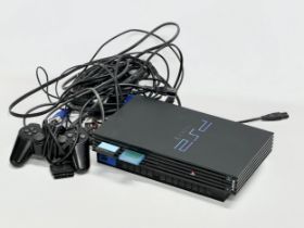 A PlayStation 2 with controller and leads.