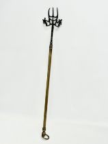 A Victorian brass extending toasting fork. 96cm open. 61cm closed.