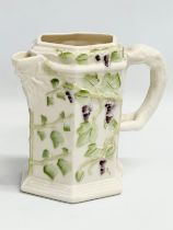 A 4th period Belleek pottery ‘Bacchus’ jug with grape vines and leaves. Early/mid 20th century.