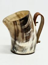 A horn drinking cup with leather handle and wooden base. 13x8x13cm