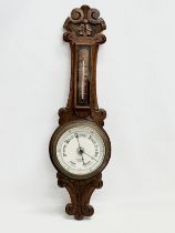 An Edwardian carved oak barometer. R.A.Browne Optician, Belfast. 72cm
